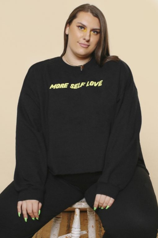 Girl wearing black cropped slogan sweatshirt